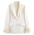 Detail eines weißen Blazers mit luxuriösen Federbündchen und klassischem Revers - XS / Tops / Weiß