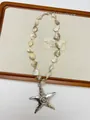 Detail of bohemian shell beaded necklace featuring a silver starfish pendant and lobster clasp - White Shell Starfish Necklace (XL3519A)