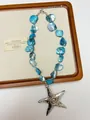 Detailed close-up of a silver starfish pendant and blue shell fragment necklace strand - Blue Shell Starfish Necklace (XL3519B)