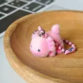 Rosa beflockter Axolotl-Plüsch-Anhänger mit Perlenkette auf einem Holztablett - Axolotl