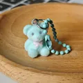 Mignon porte-clés ours floqué bleu clair avec nœud rose et chaîne à billes bleue - Petit ours vert