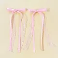 Detail of pink ballet-style lace ribbon hair clips with satin textures and long tassels - Pink
