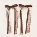 Detailed close-up of dark brown double-layered lace bow clips with elegant long ribbons - Brown