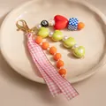 Beaded keychain with pink ribbon and orange heart beads on a beige ceramic plate - Plaid Ribbon Heart Style (ZJ16369)