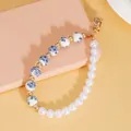 Handmade phone strap with blue floral ceramic beads and white faux pearls in gold - Blue and White Porcelain Bead Style (ZJ16317)