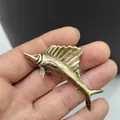 Macro shot showing retro bronze swordfish figurine details held in hand - Fish Pattern