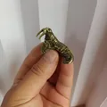 Detail of a vintage brass walrus miniature figurine held by fingers showing small size - Walrus