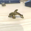 Dettaglio di una statuetta di delfino in bronzo vintage con finitura metallica antica - Delfino