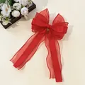 Macro detail of red organza and satin bow hair clip with layered fabric texture - Red