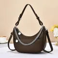 Close-up of brown litchi pattern dumpling bag with silver chain and metal charms - Coffee