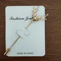 Macro detail of golden deer head brooch with crystal antlers on a display card - Gold Deer Head Style (Gold Deer)
