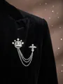 Silberne Krone und Kreuz-Anstecknadel mit mehrlagigen Ketten auf schwarzem Anzug - Kronenkreuz / Silber