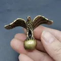 Makroaufnahme einer Vintage-Adlerfigur aus Messing, die eine Kugel mit Antik-Finish hält - Adler auf Kugel / Ministatue / Bronze