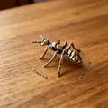 Antique brass ant figurine ornament measures 1.77 x 1.38 inches on a wood surface - Ant with Antennae