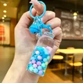 Blue bottle keychain with macaron spheres and snowflake sequins on a blue hook - Luminous Snowflake (Colored Hardware) / Lobster Clasp Style / Blue