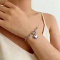 Minimalistisches Silberkettenarmband mit Herzanhänger und Knebelverschluss am Handgelenk - Ot Herzförmiges Set - 1