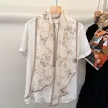 Silk scarf with butterfly pattern paired with cream shirt on a wooden hanger - Butterfly Smoke