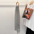 Polka dot silk scarf in sage green with brown spots hanging on a round wooden rack - Mist Brown Polka Dot