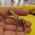 Primo piano di una statuetta in miniatura di giraffa in ottone con dettagli maculati - Giraffa