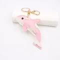 Dettaglio del portachiavi a forma di delfino in ecopelle rosa con anello dorato - Forma di Orca / Rosa