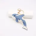 Dettaglio portachiavi a forma di orca in pelle con cuciture bianche e gancio dorato - Forma di Orca / Blu