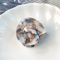Elegante molletta a conchiglia in acrilico marmorizzato avorio e blu con fili dorati - Ciano Dorato