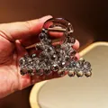 Macro detail of large hair claw clip with grey faceted crystals and brown acrylic base - Full Strawberry Bead Inlaid Style / Gray