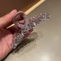 Dettaglio macro di una grande pinza per capelli coreana con cristalli viola e raso rosa - Stile Satinato con Diamanti a Cuore / Viola