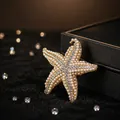 Elegant gold starfish brooch with white faux pearls and sparkling rhinestones - Starfish