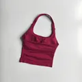 Detailed view of burgundy halter neck sports bra with ribbed compression and ruched chest - Raspberry