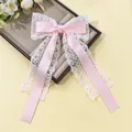 Détail d'un nœud papillon en satin rose avec dentelle florale blanche et longs rubans - Rose Clair