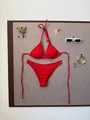 Flat lay of red ribbed bikini set with sunglasses and summer decor on neutral background - Red