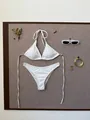 Flat lay of white ribbed two-piece bikini with halter top and sunglasses on a board - S / White