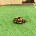 Dettaglio ravvicinato di un ciondolo a cobra in ottone antico con squame incise - Ottone / Ciondolo Pitone