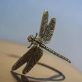 Dettaglio macro di una libellula in rame vintage con ali finemente decorate e incise - Libellula Grande Dorata