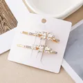 Gros plan sur deux barrettes papillon dorées élégantes serties de strass en cristal - Papillon Zirconia Blanc