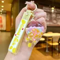 Yellow silicone keychain with liquid sand bottle, cherry blossoms, and macro beads charms - Yellow Glow-in-the-dark Bean Cheese Sticks