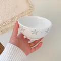 White ceramic bowl with blue starfish pattern held in hand for scale and size - 4.5 Inch Bowl
