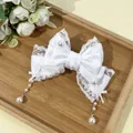 Détail d'une barrette nœud en satin blanc avec dentelle et glands en perles - Blanc