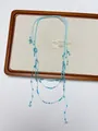 Detail of light blue handmade beaded necklace with bohemian fringe on canvas board - Style L Light Blue Multi-layer Tassel Necklace (XL3610B)