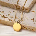 Collana minimalista con ciondolo rotondo e catena a serpente dorata su pietra - Ciondolo a moneta