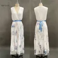 Detail van een elegante mouwloze geplooide maxi-jurk met V-hals en blauwe ceintuur - S / Abrikoos