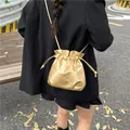 Metallic gold drawstring bucket bag in soft faux leather with elegant crossbody strap - Gold