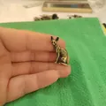 Macro detail of a miniature bronze Sphinx cat figurine held by hand for scale - Sphynx Cat / Bronze