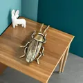 Detalle macro de las alas de langosta en latón envejecido sobre mesa de madera - Cucaracha