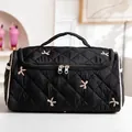 Black quilted makeup bag with pink bow embroidery and white piping detail - Embroidered Black Bow