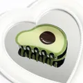 Creative green avocado hair claw clip with brown core detail on white heart mirror - Avocado