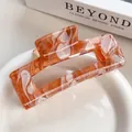 Rectangle hair claw clip with orange and white marble textured acetate finish - Rock Red