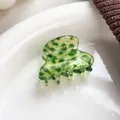 Elegant translucent green acetate hair claw with marble pattern on a ceramic tray - Green Spotted (3cm)