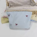 Detail der roten Schleifenstickerei auf der blau-weiß gestreiften Kulturtasche - Blau Gestreift Roter Bogen